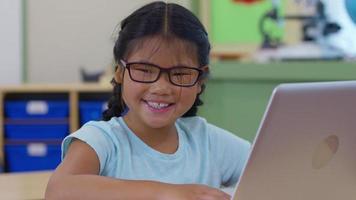 ritratto di giovane ragazza in aula scolastica con computer portatile video