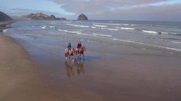 Luftaufnahme von Frauen, die Pferde am Strand reiten