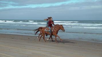 tir super ralenti de femmes à cheval sur la plage, oregon, tourné sur fantôme flex 4k video