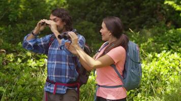Couple hiking takes break to look through binoculars video