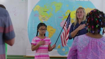 Teacher and student saying pledge of allegiance in school classroom video