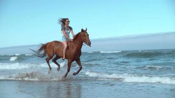 Tiro de cámara super lenta de mujer montando caballos en la playa, oregon, rodada en phantom flex 4k video
