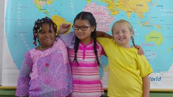 Retrato de tres niñas multiculturales en el aula de la escuela. video