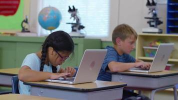 los estudiantes trabajan en computadoras portátiles en escritorios en el aula de la escuela video