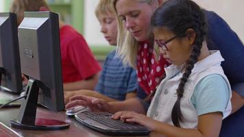 profesor y alumno en el aula de la escuela trabajando en la computadora video