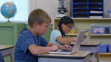 Students in school classroom working on laptop computers video