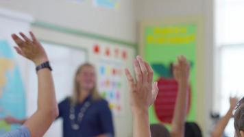 professor dá aula na sala de aula e os alunos levantam as mãos, foco na prateleira video