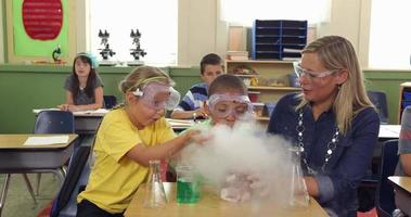 Teacher and students doing science experiment in school classroom video