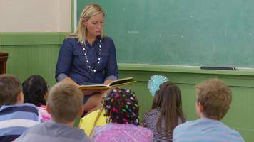 Teacher reads book to kids in school classroom video