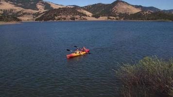 Aerial view of mother and son paddling canoe on lake video