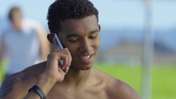 tonåring basketspelare talar i mobiltelefon på utomhus domstol