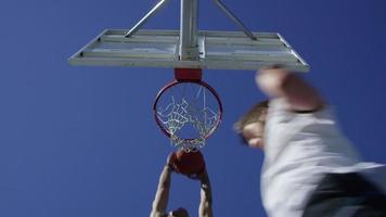 Low angle slow motion shot of man making a slam dunk video