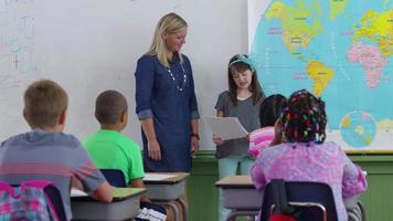 Student in front of class reading report video