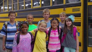 Portrait of group of students in front of school bus video