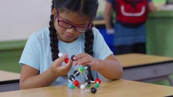jong meisje dat een molecuulmodel bouwt video