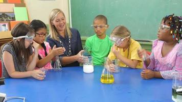 profesor y estudiantes haciendo experimentos científicos en el aula de la escuela video