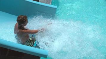 Boy going down waterslide in super slow motion video