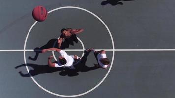 Friends playing basketball at park, overhead shot of tip off video