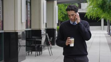 Young businessman talking on cell phone outdoors
