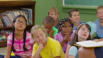 Kids listen to teacher read book in school classroom video