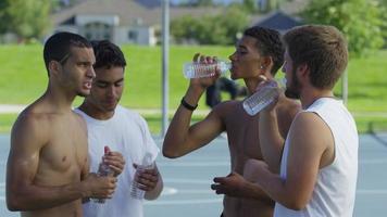 Group of teen basketball players taking water break video