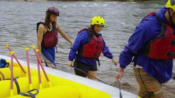 grupo de personas rafting en aguas bravas llevar balsa juntos