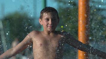 Boy playing in sprinkler at park in super slow motion video