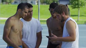 grupo de jogadores adolescentes de basquete olhando para um tablet digital