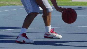 Friends playing basketball at park, dribbling closeup video