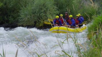 Group of people white water rafting in slow motion video
