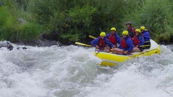 Group of people white water rafting in slow motion video