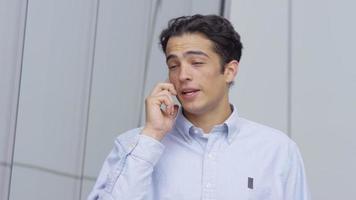 Closeup shot of young businessman talking on cell phone outdoors
