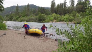 gruppo di persone che fanno rafting portano insieme la zattera video