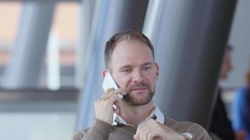 Young businessman using cell phone in office lobby video