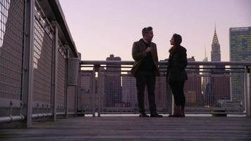 Couple in New York City standing on pier with city skyline in background video