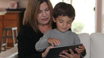 mãe e filho usando tablet digital juntos video