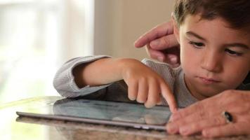 madre e hijo usando tableta digital juntos video