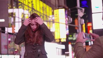 casal tirando fotos de celular na Times Square, Nova York video