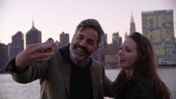 par i new york city tar mobiltelefonselfie med stadshorisont i bakgrunden