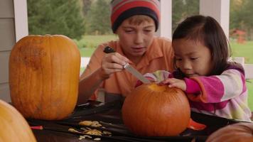 Kids carving pumpkins for Halloween video