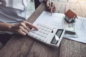 Customer uses pen and calculator to calculate home purchase loan photo