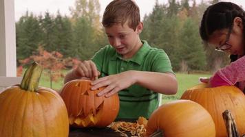 enfants découpant des citrouilles pour halloween video