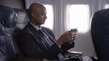 Businessman using digital tablet on airplane video