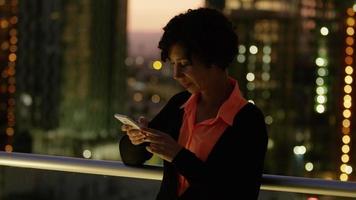 femme utilisant un téléphone portable la nuit en ville