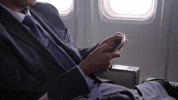 Businessman talking on cell phone on airplane flight video