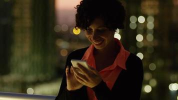 Mujer con teléfono celular por la noche en la ciudad video