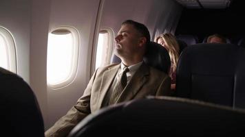 l'uomo sull'aereo chiude il finestrino e si riposa