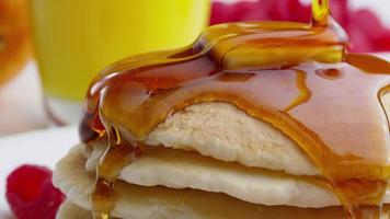 Pouring syrup onto pancakes