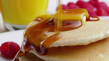 Pouring syrup onto pancakes, closeup video