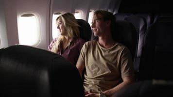 Couple talking and looking out window on airplane flight video